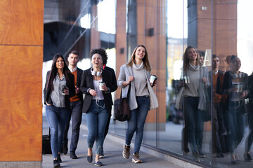 Group of people walking on a street with confidence. Businessmen and businesswomen traveling together..