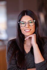 Beautiful girl with glasses. Portrait of a smart businesswoman in a reataurant.