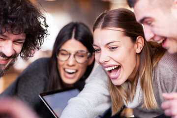 Young successful business people having a creative meeting at a cafe. Smiling and happy face expressions..