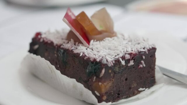Maltese pastry Pudina served in restaurant in Malta. Traditional Maltese Kwarezimal feat bread pastry in Malta street caf&eacute;. A delicious chocolate cake served in a white plate on the wooden table.
