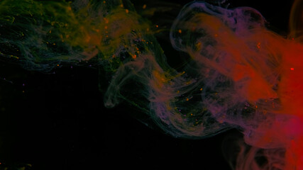 Drops of yellow, purple and orange ink in water. Yellow, purple and orange watercolor paints in water on a black background. Awesome abstract background. Beautiful wallpaper for your desktop.