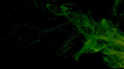 Drops of green ink in water. Cosmic star background. Green watercolor paints in water on a black background. Beautiful wallpaper for your desktop. Green cloud of ink.