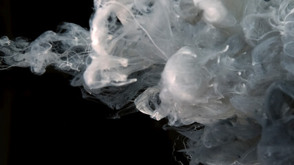 White cloud of ink on a black background. Drops of white and gray ink in water. Cosmic star background. Awesome abstract background.