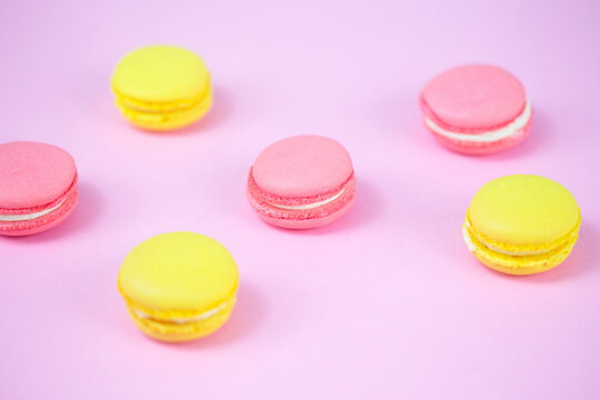 Pink and yellow macaroons, tasty sweet biscuits on a table.