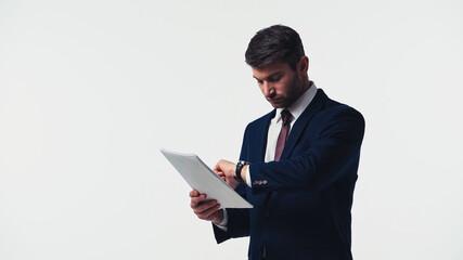 Businessman looking at wristwatch while holding papers isolated on white