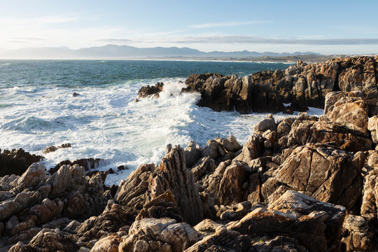 The jagged rocks and rock pools on an ocean coastline with waves breaking