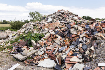 A pile of builders rubble dumpde in the countryside.