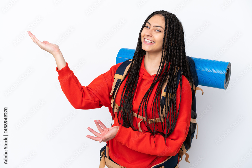 Poster hiker teenager girl with braids over isolated white background extending hands to the side for invit