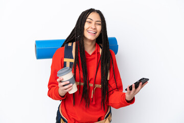 Naklejka premium Hiker teenager girl with braids over isolated white background holding coffee to take away and a mobile