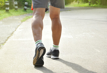 an old man legs and muscles(selective focus) while running along the street, concept elderly people health care