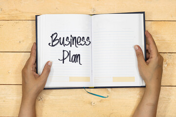 hands woman holding a notebook or agenda with Business Plan Growth Concept