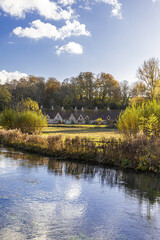 Autumn in the Cotswolds - The River Coln, Rack Isle and Arlington Row in the village of Bibury,...