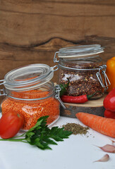 
Red and green lentils in a glass jar with vegetables (onions, carrots, peppers, chili, tomato, garlic) and spices. Vegetarian cuisine. Ingredients.