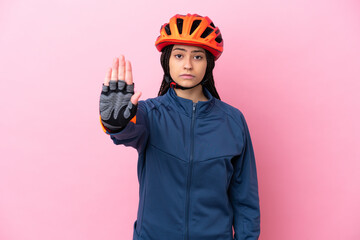 Teenager cyclist girl isolated on pink background making stop gesture - obrazy, fototapety, plakaty