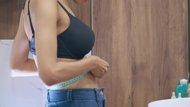 Slim female measuring waistline with tape, eating disorder, body care, anorexia