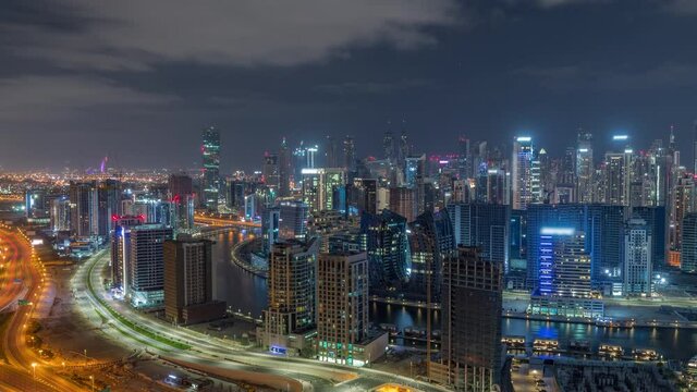 Skyline with modern architecture of Dubai business bay towers all night timelapse. Aerial view