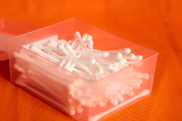Cotton swabs for ears on an orange background