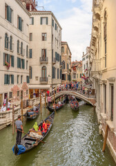 Fototapeta na wymiar venice veneto Italy July 24 2017 Tributory canal with gondolas, bridge and tourists