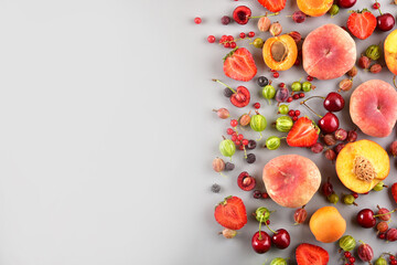 Naklejka na ściany i meble Multi-colored different fruits on a gray background. Place for text.