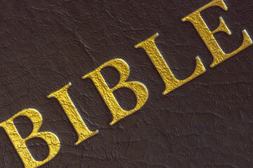 The inscription on the cover of the book, The Bible, a collection of religious texts, close up.