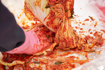 Close-up of hands making kimchi