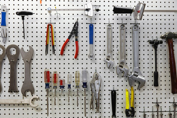 Cycle repair shop interior, tool boards and tools at a service counter.