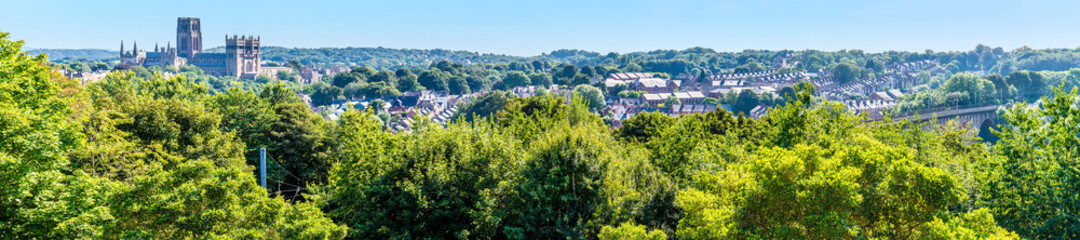 A panorama view across the treetops towards the city of Durham, UK in summertime