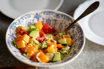 Cucumber and tomato salad with sour cream at a regular kitchen stop at home.