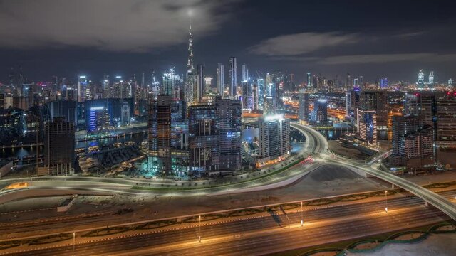 Panoramic skyline of Dubai with business bay and downtown district all night timelapse.