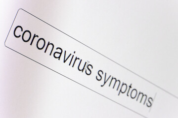 Search bar on a computer monitor with the question Coronavirus symptoms. Searching for information on the Internet, close up.