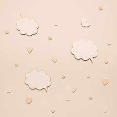 Beautiful beige monochromatic background with conversation box and wooden hearts. Minimal flat lay idea of conversation made with love.