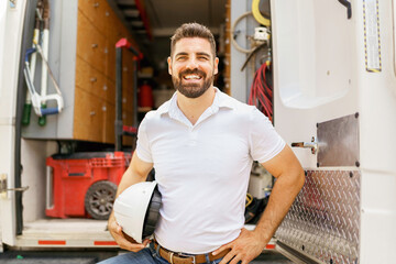 man with a hard hat standing in front of truck - Powered by Adobe