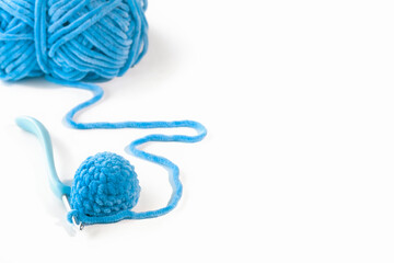 Needlework crochet with a skein of blue yarn on a white background