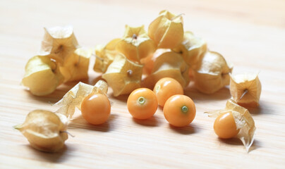Fresh ground cherries on a wooden table harvested from a backyard garden.