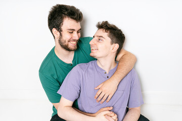 Young gay couple standing together over isolated background