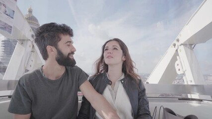 Romantic young couple sitting laughing and smiling together on ferris wheel looking at landmarks and city skyline, young adults tourists visiting Brussels , Europe travel destination, romance concept