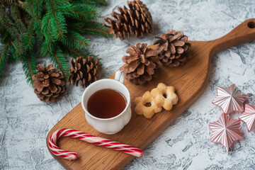 Obraz na płótnie Canvas New Year's or Christmas composition black tea on a wooden stand with cookies and candy among spruce green branches