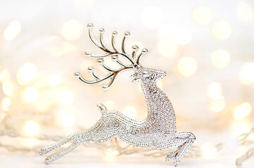 Christmas composition. A silvery deer and lights on the background