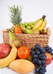 Mix variety of fresh juicy colorful exotic tropical fruits in basket on white background