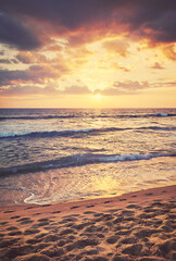 Tropical sandy beach with footprints in the sand at sunset, color toning applied, Sri Lanka.