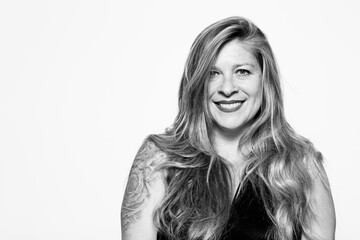 Black and white portrait of smiling middle-aged woman on white background