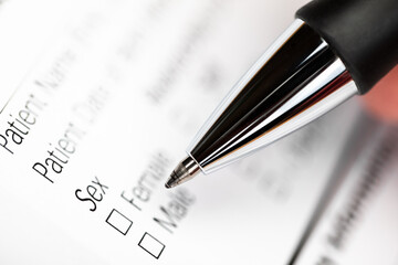 Fototapeta premium Hand with pen over gender option checkboxes in a form
