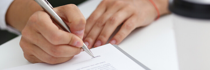 Female hand holding silver pen ready to make note