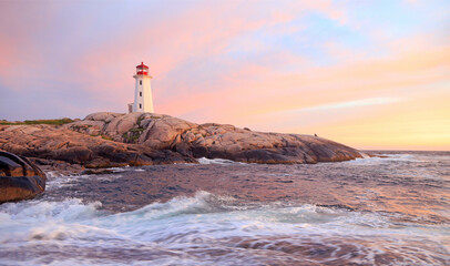 Peggy’s Cove Lighthouse illuminated at sunset with dramatic purple sky and waves, Nova Scotia, Canada