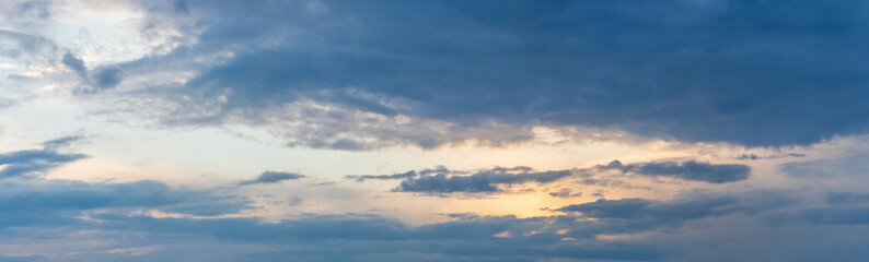 Naklejka na ściany i meble Dark clouds in the evening sky at sunset