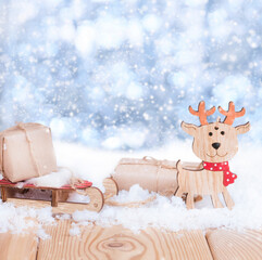 christmas presents on the wooden sled and noel toy in the snow on the nature blue background 
