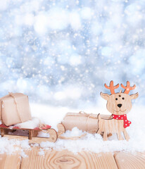 christmas presents on the wooden sled and noel toy in the snow on the nature blue background with copy space	