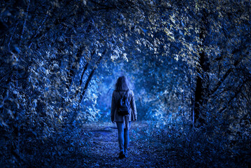 Dark forest on Halloween, young woman in fantasy spooky woods at night