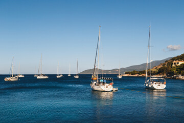 Fototapeta na wymiar White yachts anchored in blue bay of Agia Efimia port, Cephalonia island, Greece.