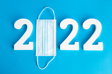 Year 2022 made up of numbers and a medical mask. Covid-19 concept.